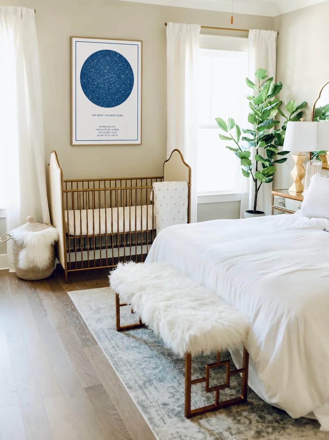 A framed navy star map titled The Night You Were Born above a gold crib in a bright bedroom
